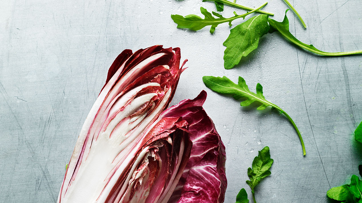 Några blad bitter ruccola samt en bit röd sallad symboliserar grundsmaken beska.