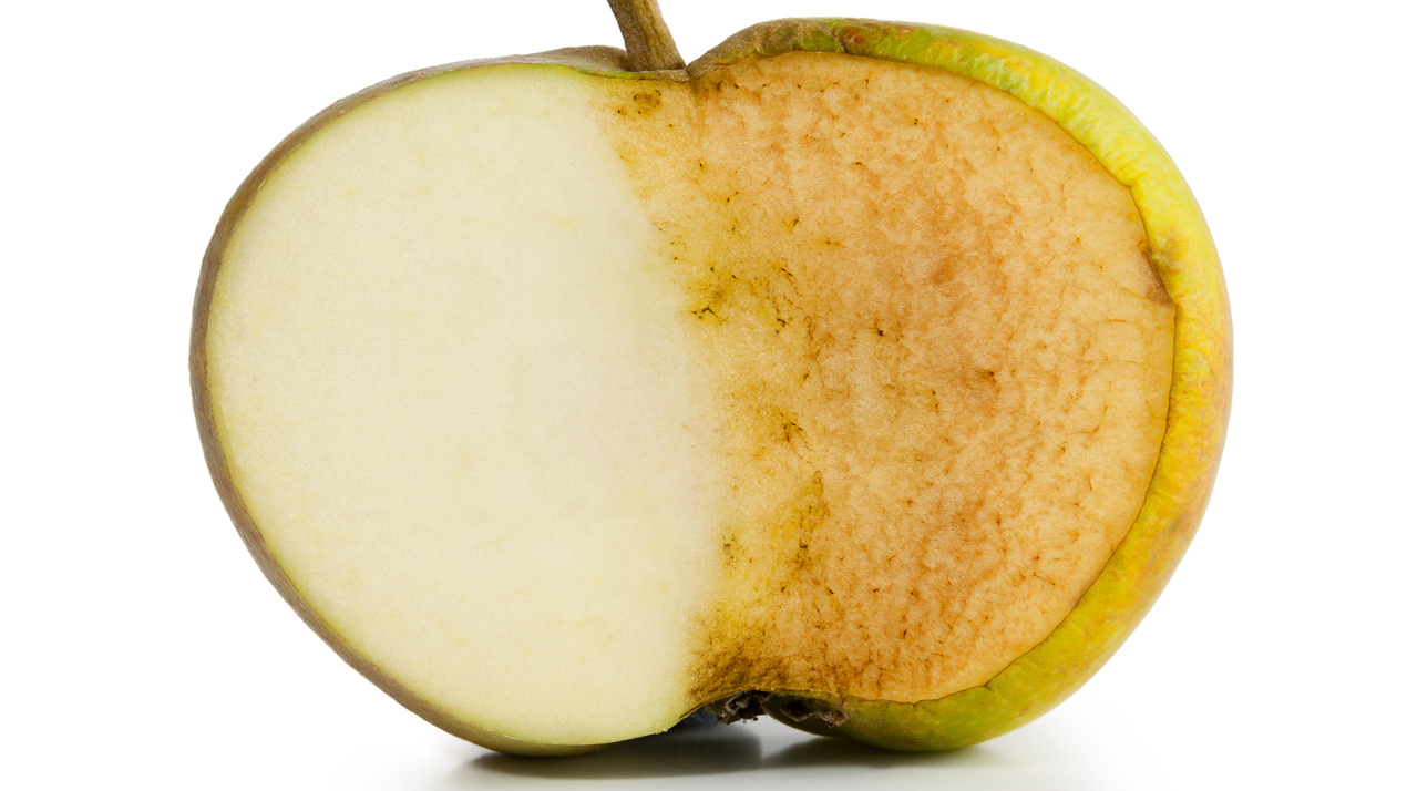 Ett delat &auml;pple d&auml;r v&auml;nster sida &auml;r ljust och h&ouml;ger sida &auml;r brunt.