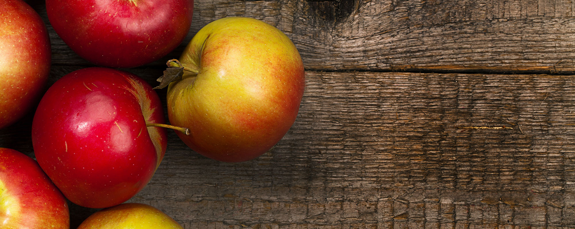 Röda och gula äpplen på ett bord.