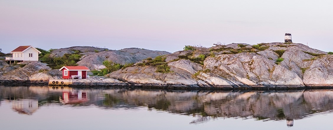 Skärgården, vatten, kobbar och röd samt vit stuga