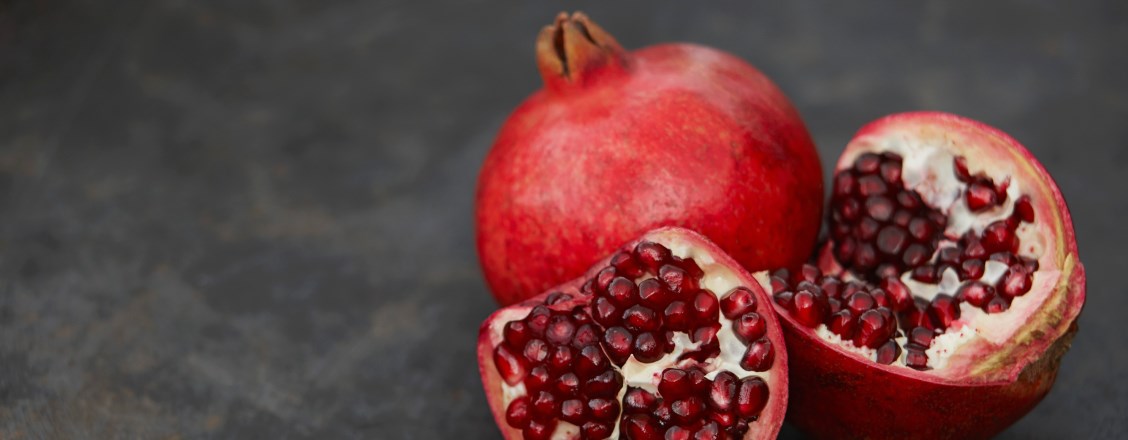 Halverat granatäpple på mörkgrå bakgrund
